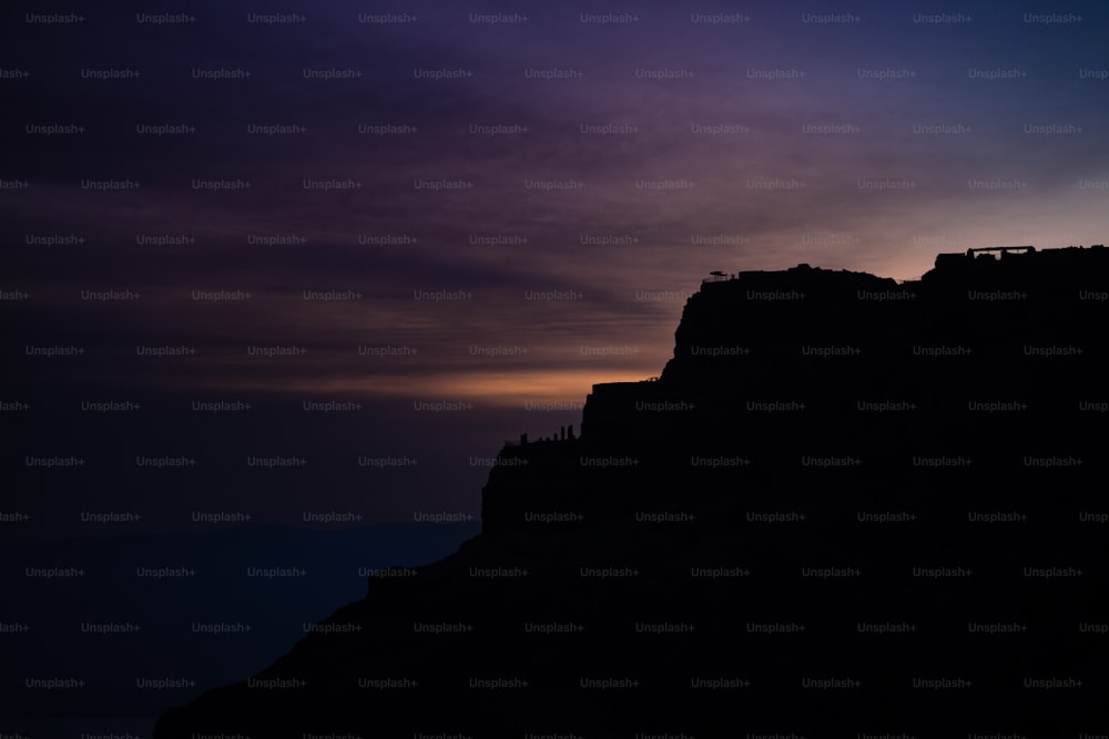 a silhouette of a castle on top of a mountain