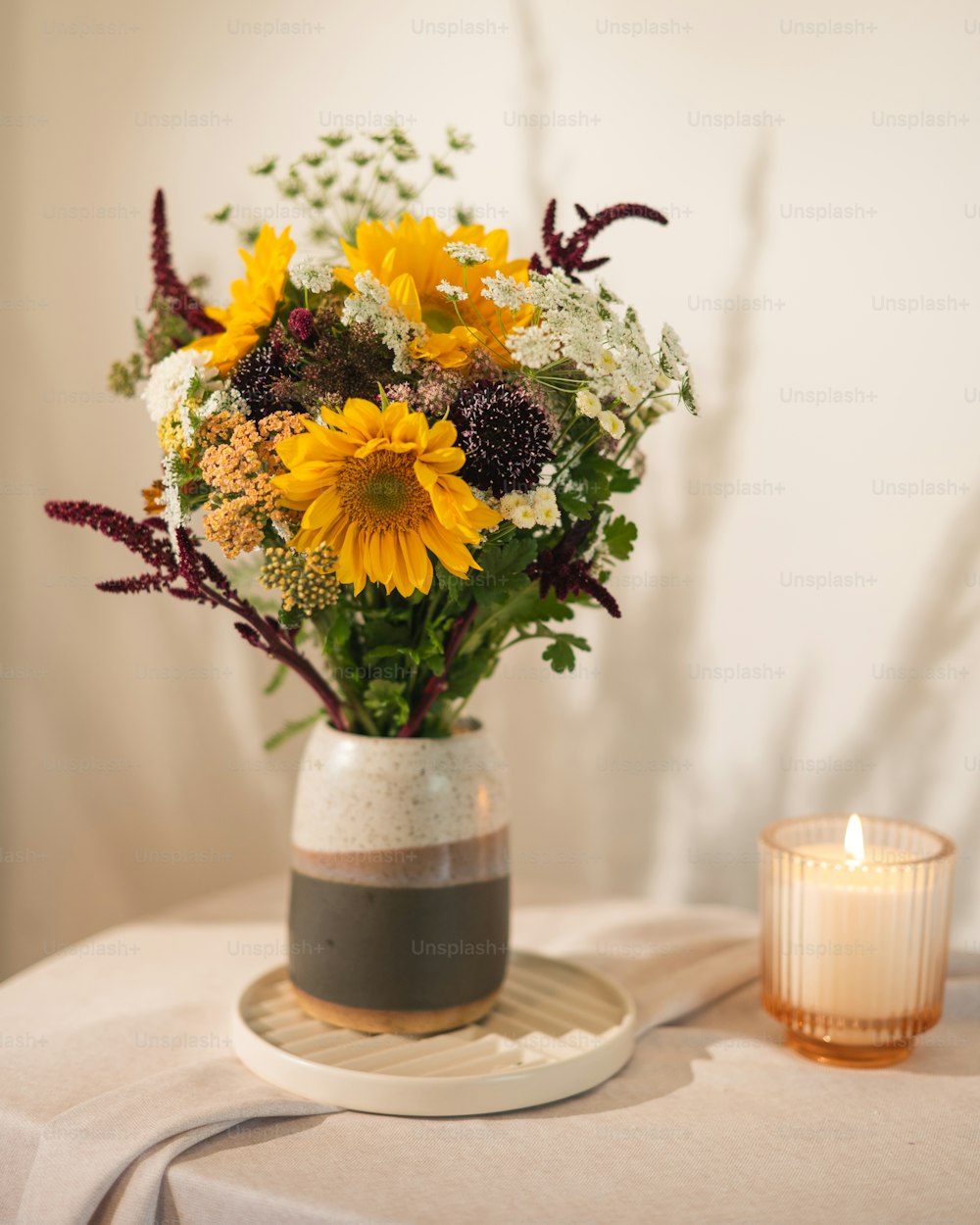 Un jarrón lleno de muchas flores encima de una mesa