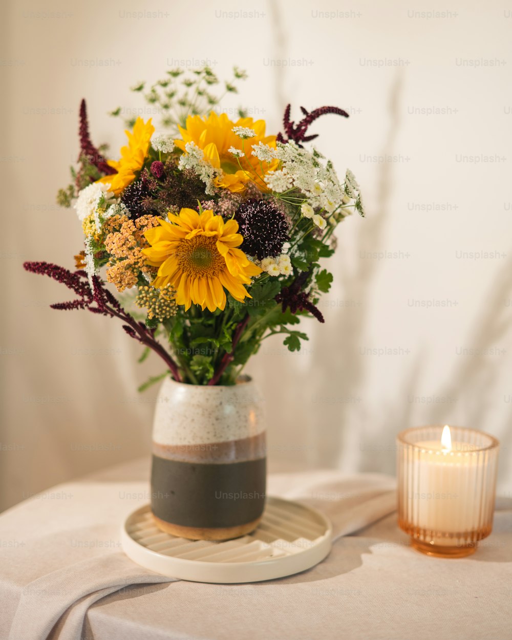 a vase filled with lots of flowers on top of a table