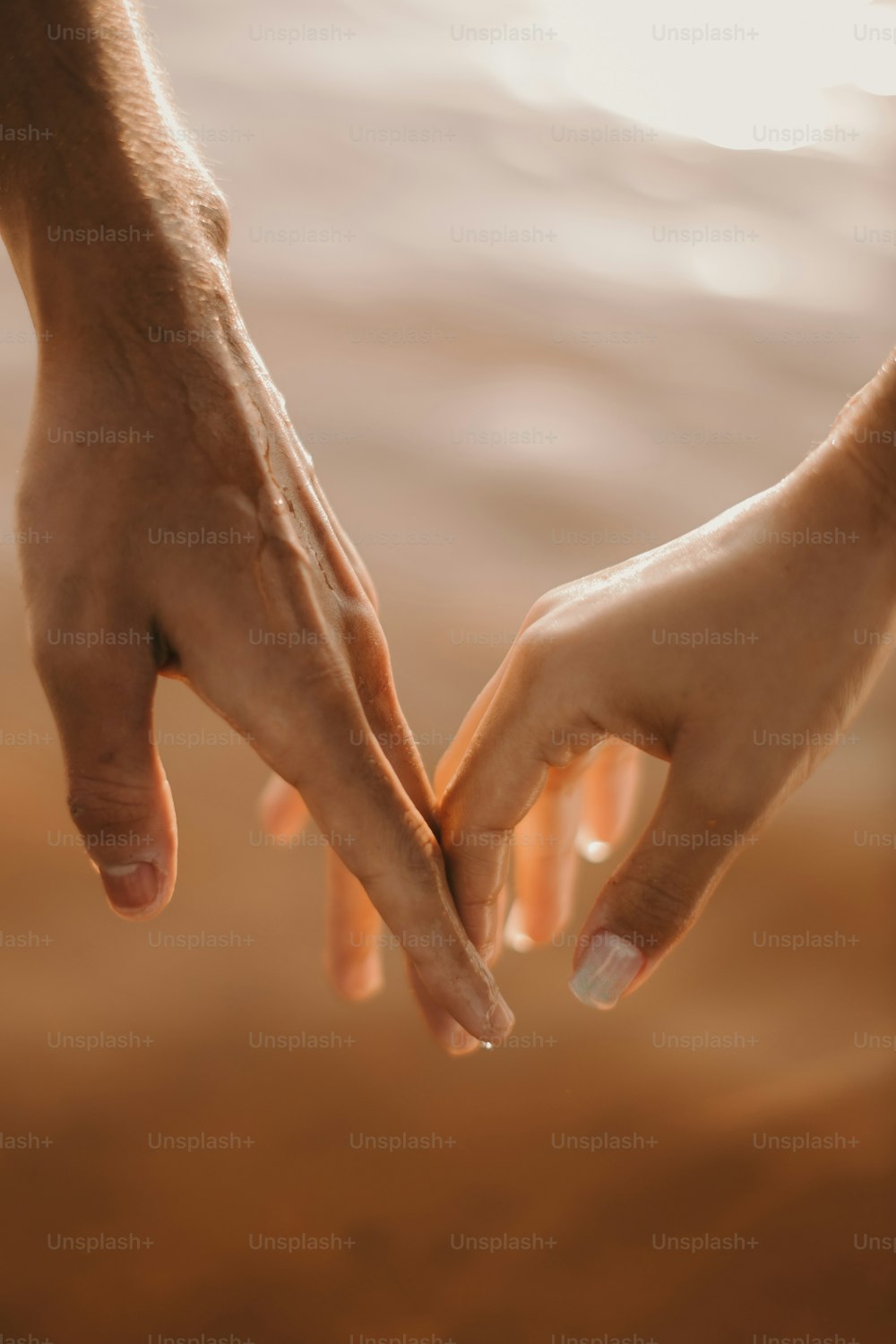 a couple of people holding hands over a body of water