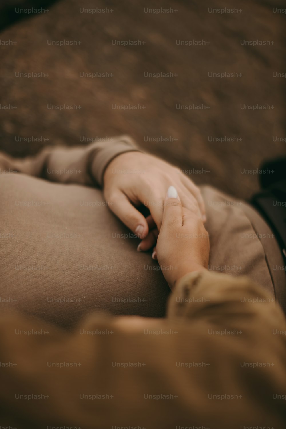 a close up of a person's hand resting on a couch