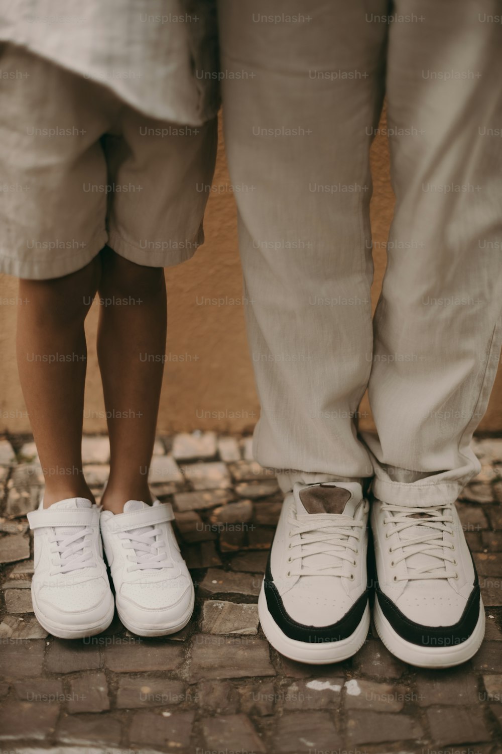 two people standing next to each other wearing white shoes