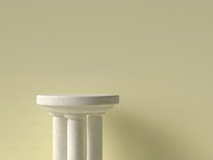 Un primer plano de un pedestal blanco contra una pared amarilla