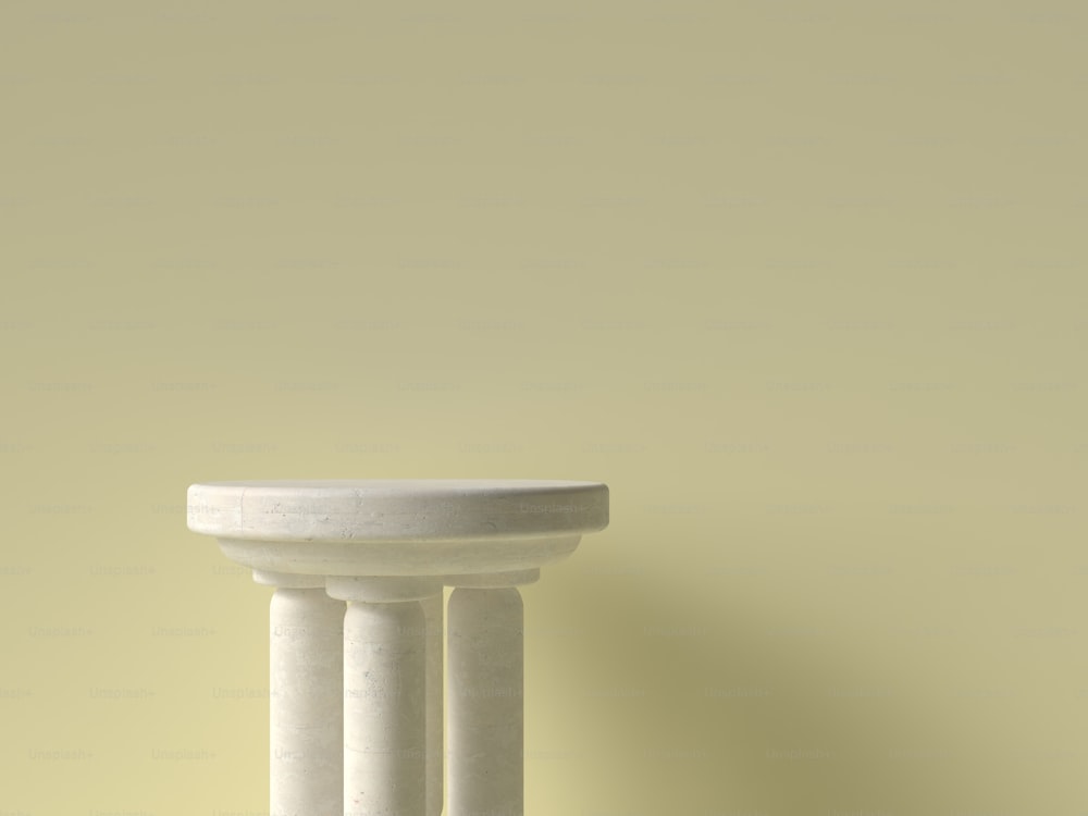 a close up of a white pedestal against a yellow wall