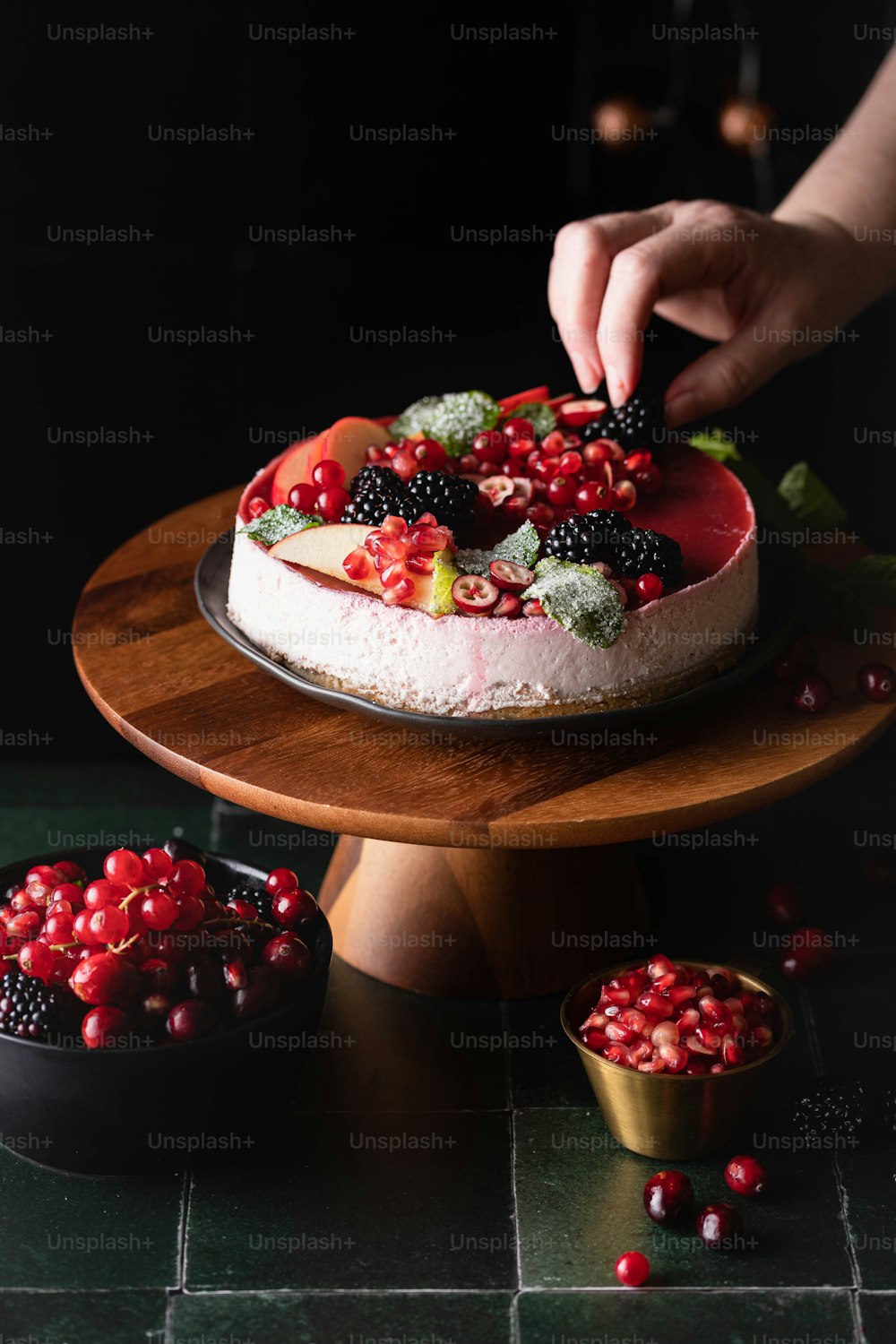 a person is decorating a cake with berries