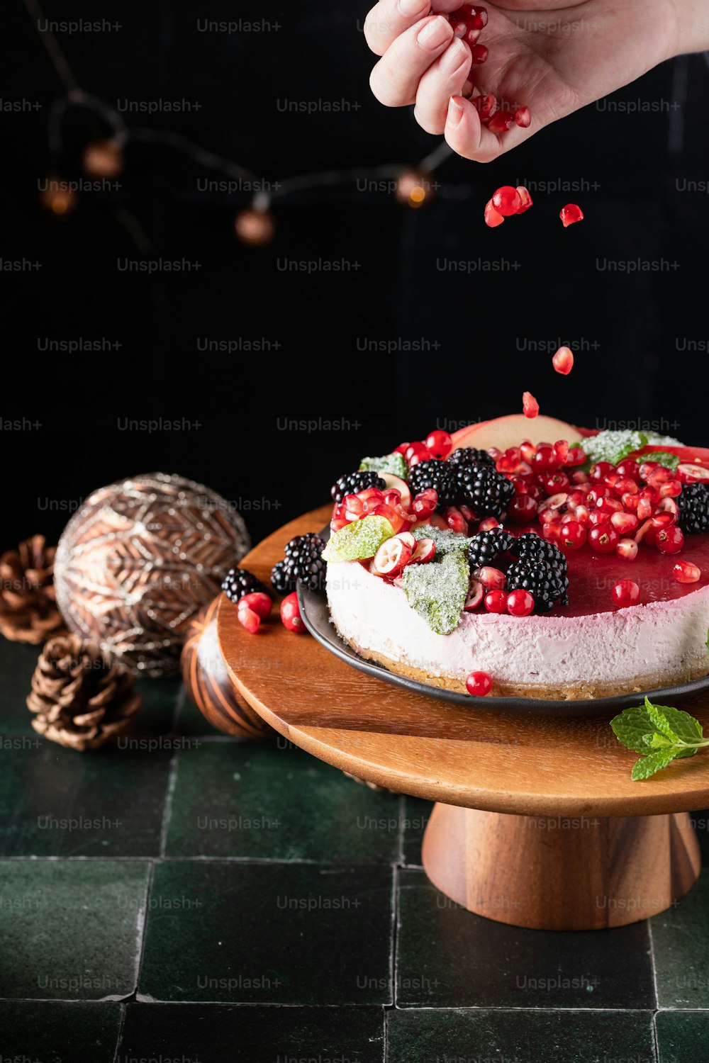 a person is sprinkling berries on a cake