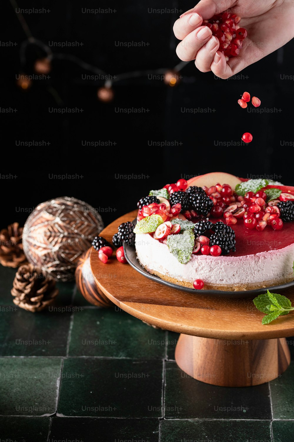 a person is sprinkling berries on a cake