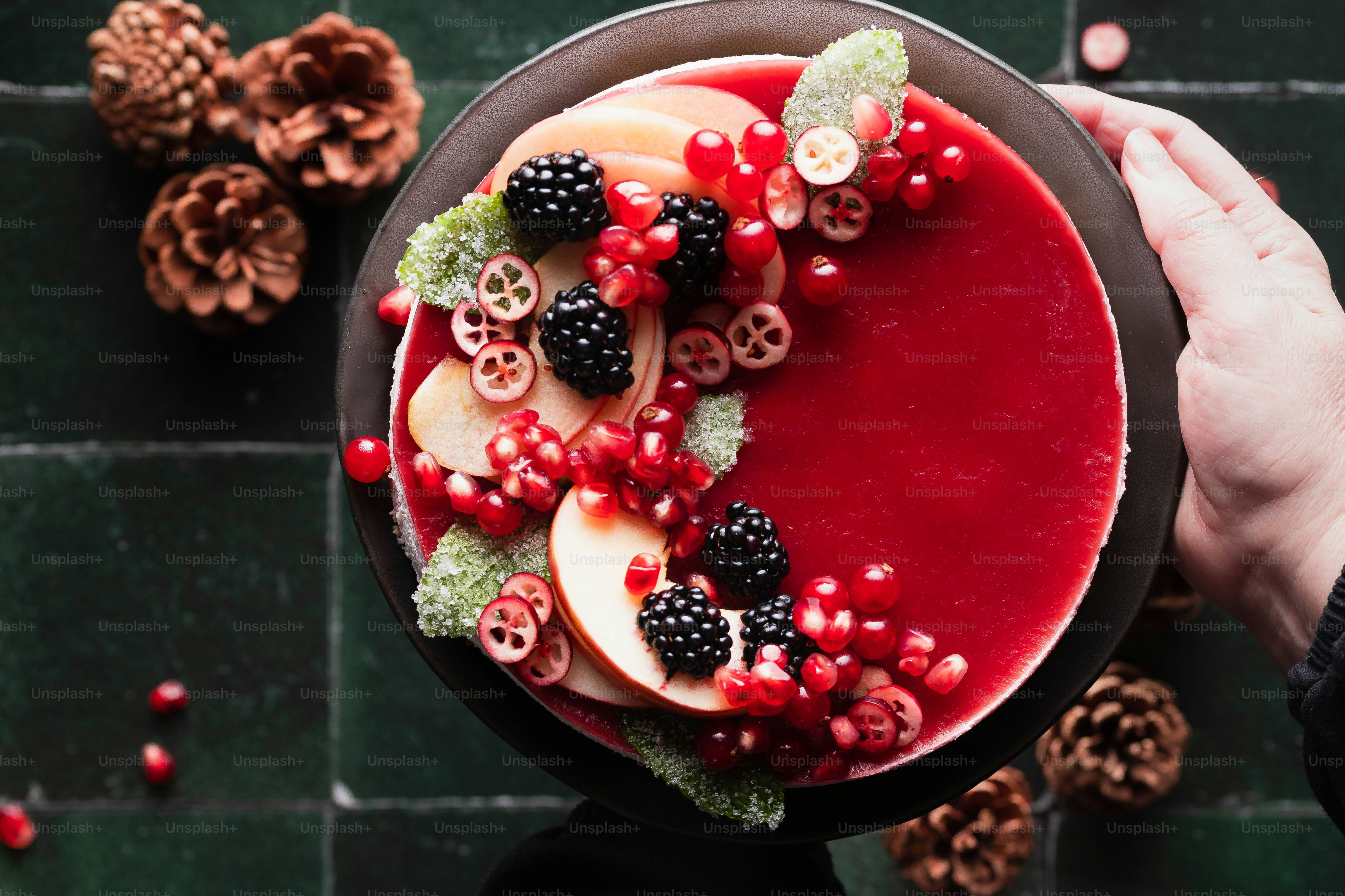 a person holding a plate of fruit and berries