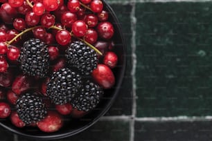 a bowl of berries and blackberries on a table
