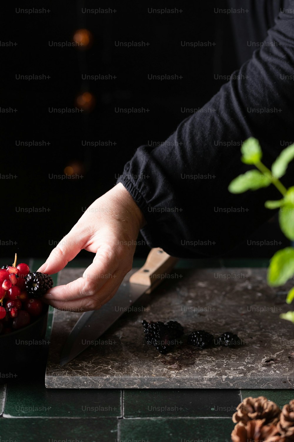한 사람이 도마에 열매를 자르고 있다