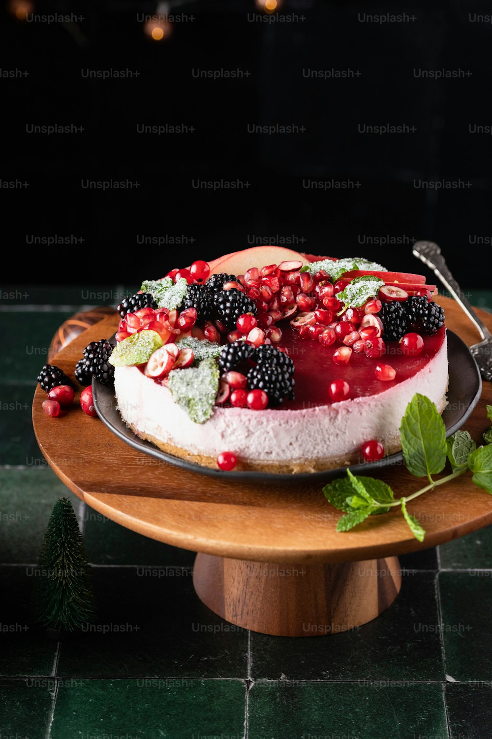 um cheesecake com frutas vermelhas e hortelã em um prato de madeira