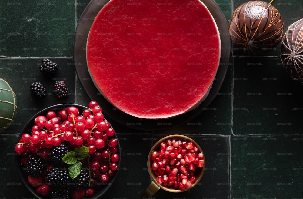 uma mesa coberta com uma tigela de frutas ao lado de uma tigela de frutas vermelhas