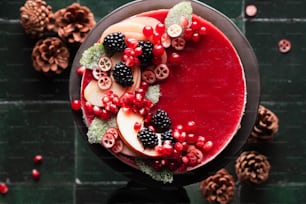a red dessert with berries and pine cones