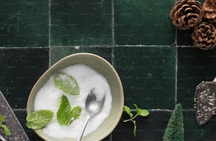 a bowl of sugar and mint with a spoon