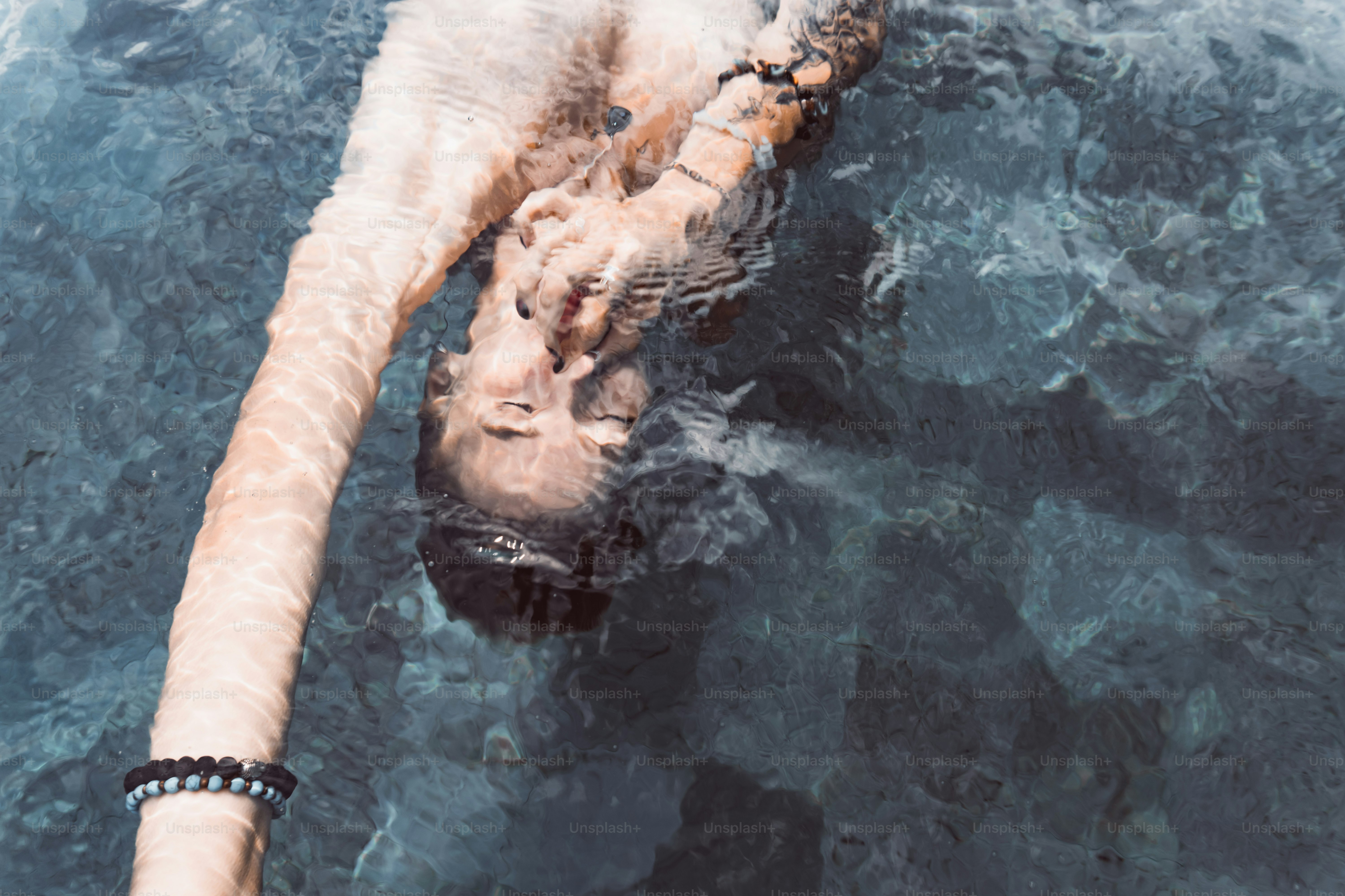 eine Person, die mit den Füßen im Wasser im Wasser schwimmt