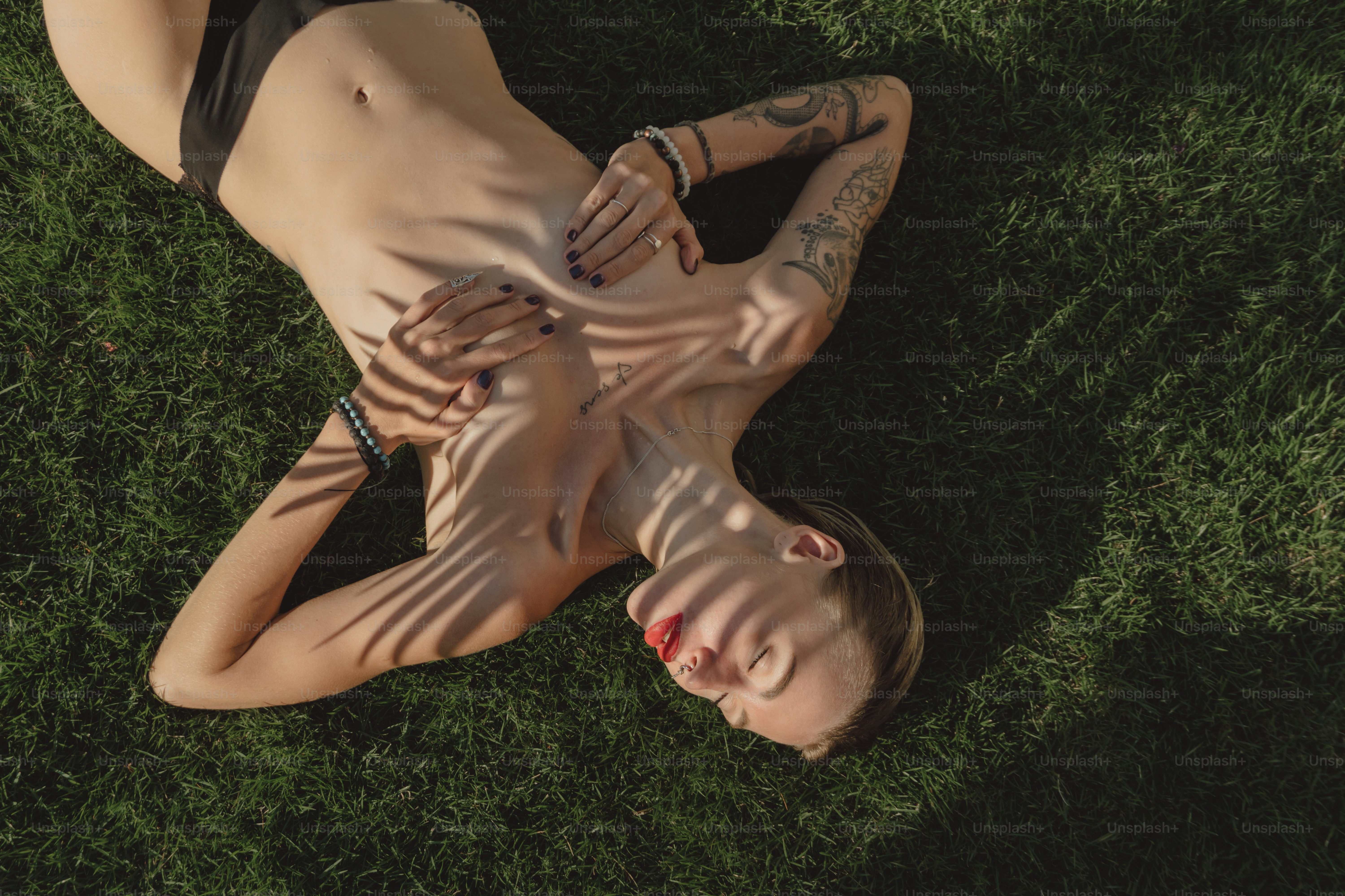 a woman laying on top of a lush green field