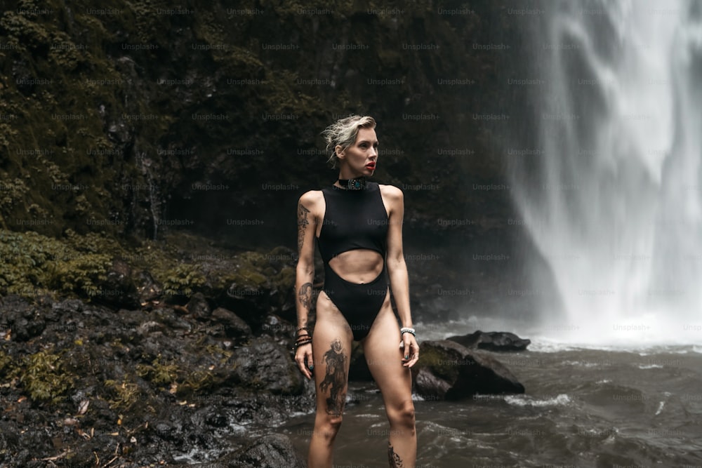 Una donna in piedi davanti a una cascata