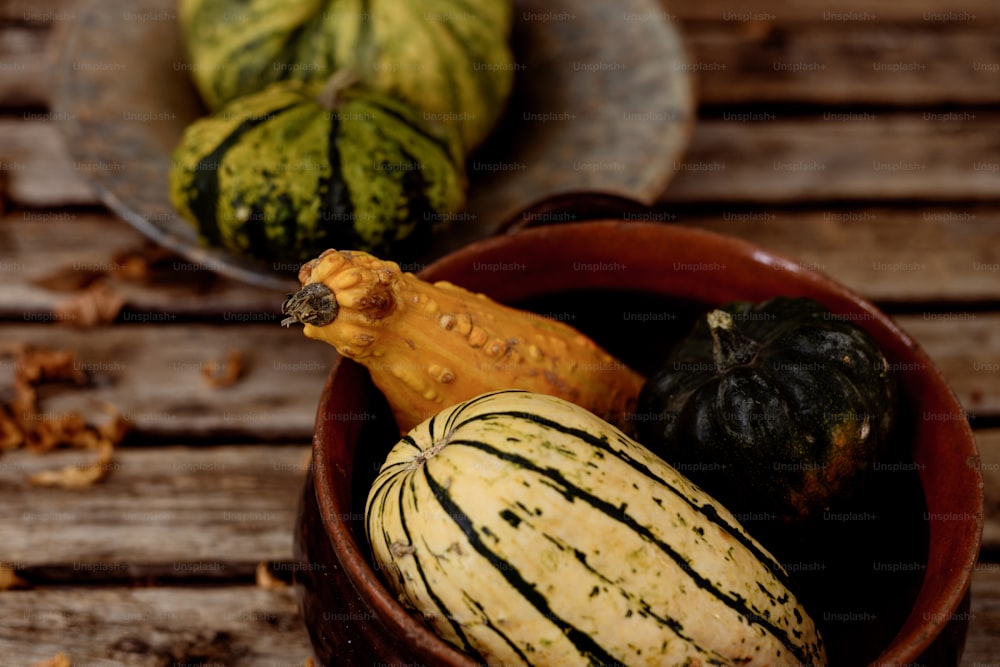 a bowl filled with different types of gourds