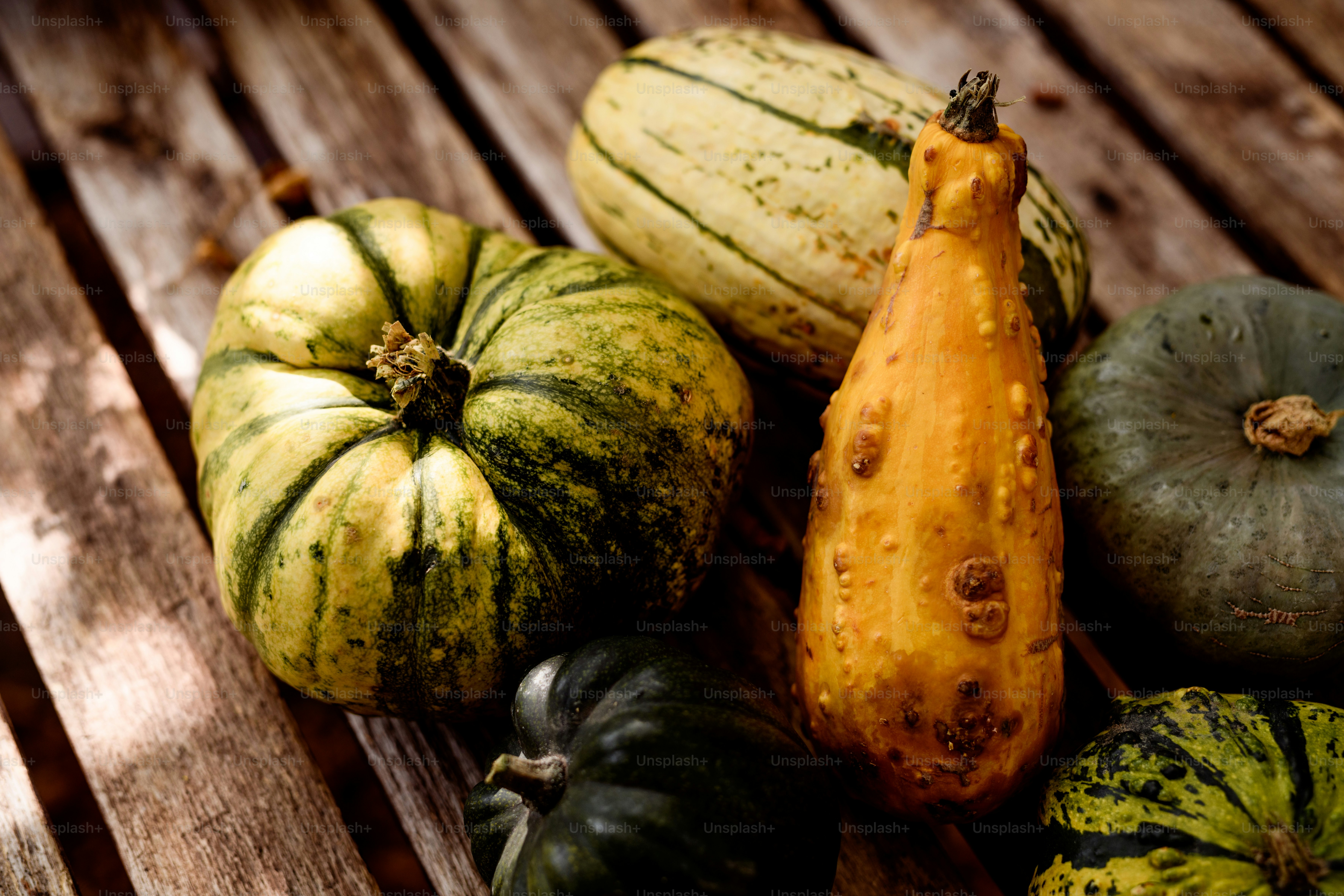 um grupo de abóbora sentado em cima de uma mesa de madeira