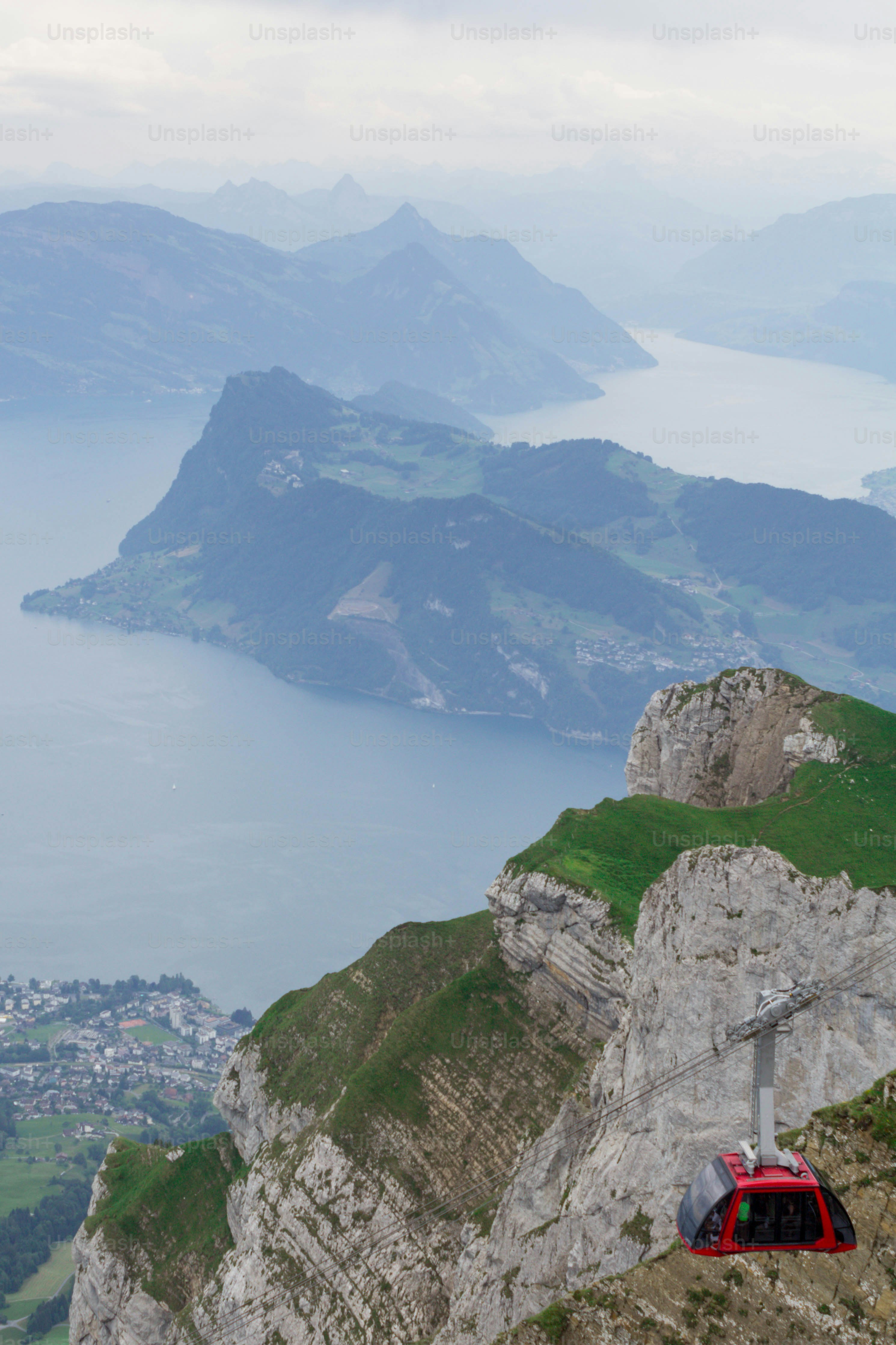 a red cable car on the side of a mountain