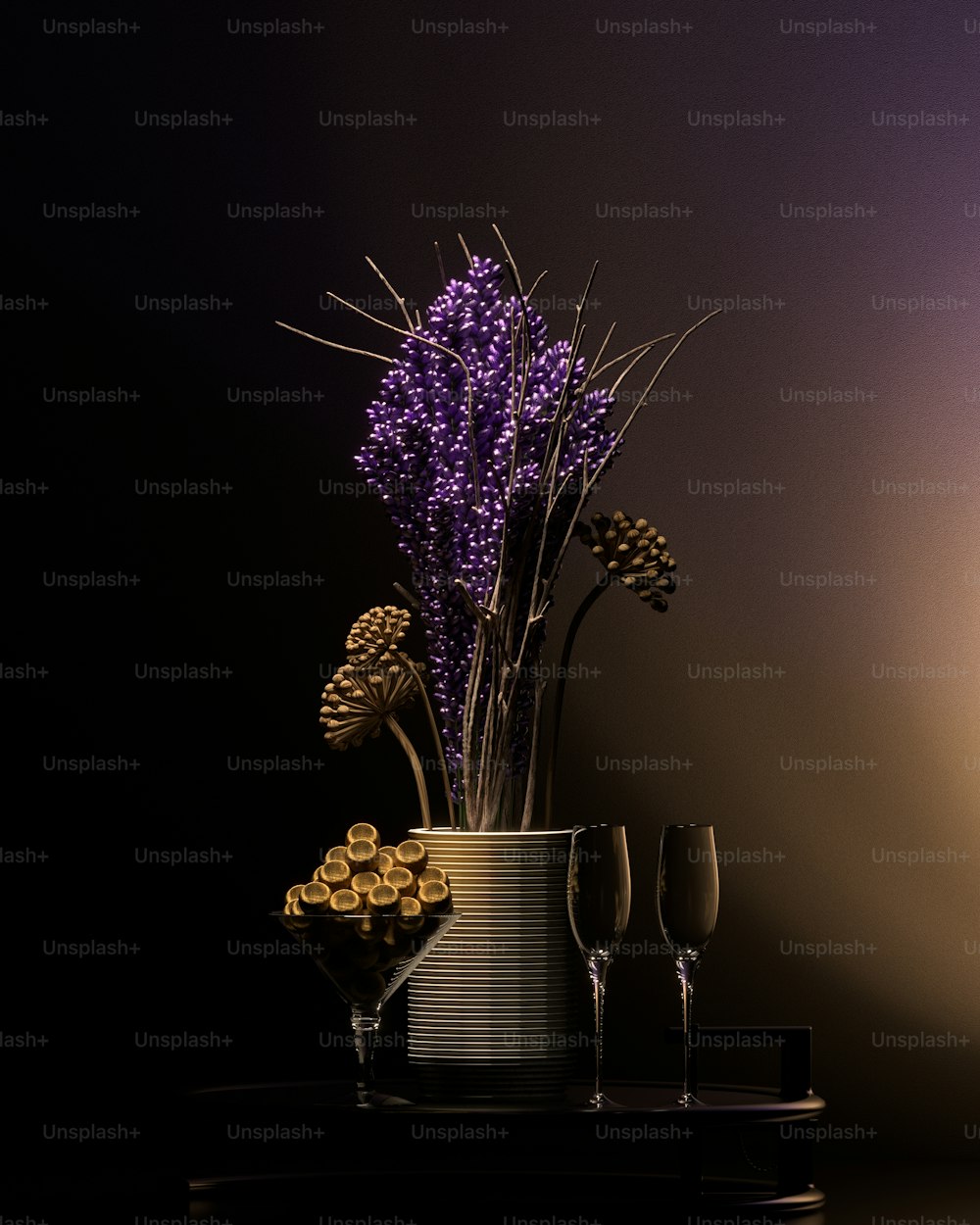 eine Vase gefüllt mit lila Blumen neben zwei Weingläsern