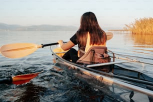 a woman is paddling a canoe in the water