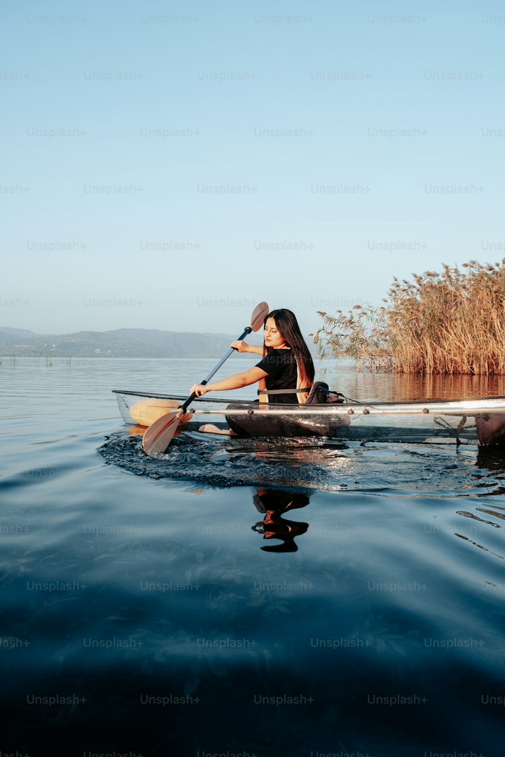 한 여자가 물 위에서 카누를 젓고 있다