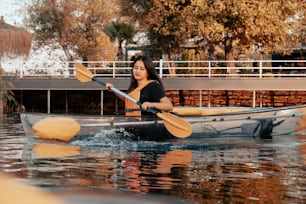 a woman is paddling a canoe in the water