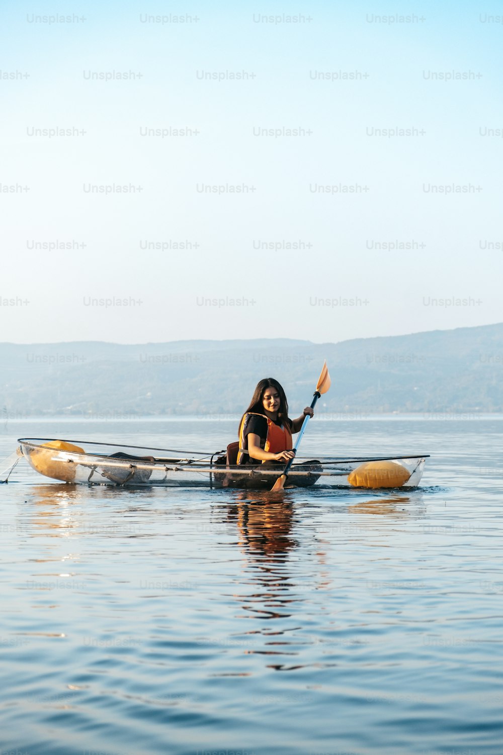 uma mulher em uma canoa remando na água