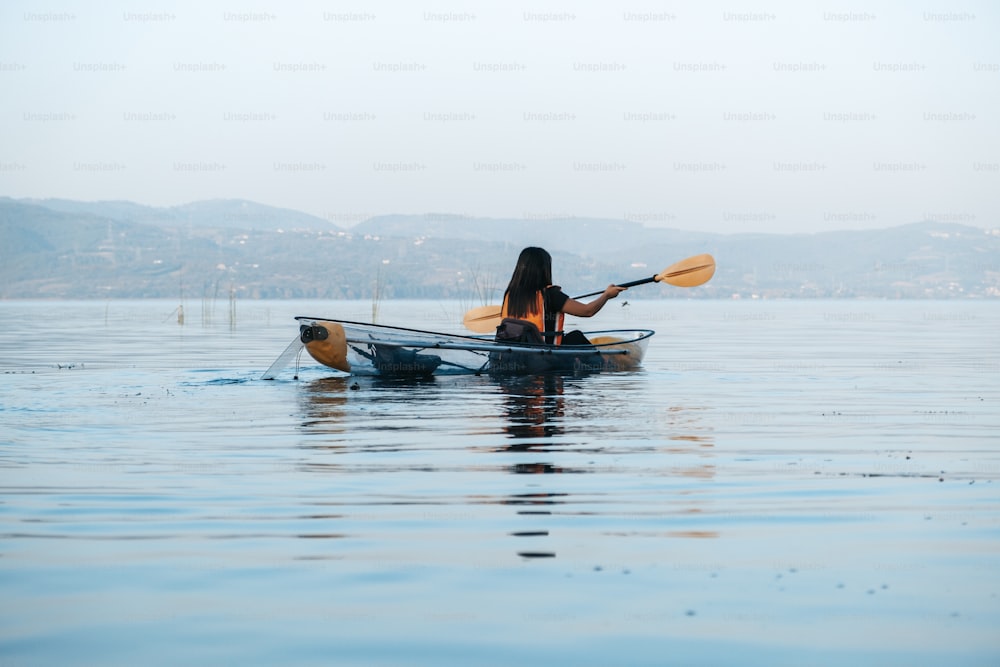 uma mulher em um caiaque remando na água