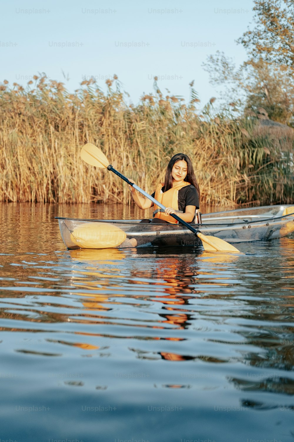 a woman sitting in a kayak on a lake