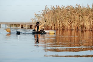 a woman is paddling a boat in the water