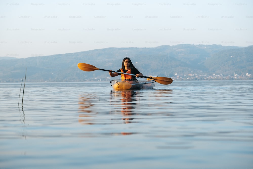 Una donna in un kayak che pagaia sull'acqua