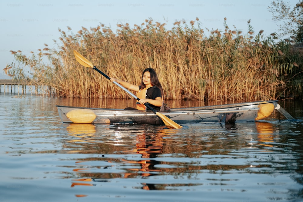 a woman is paddling a canoe on the water