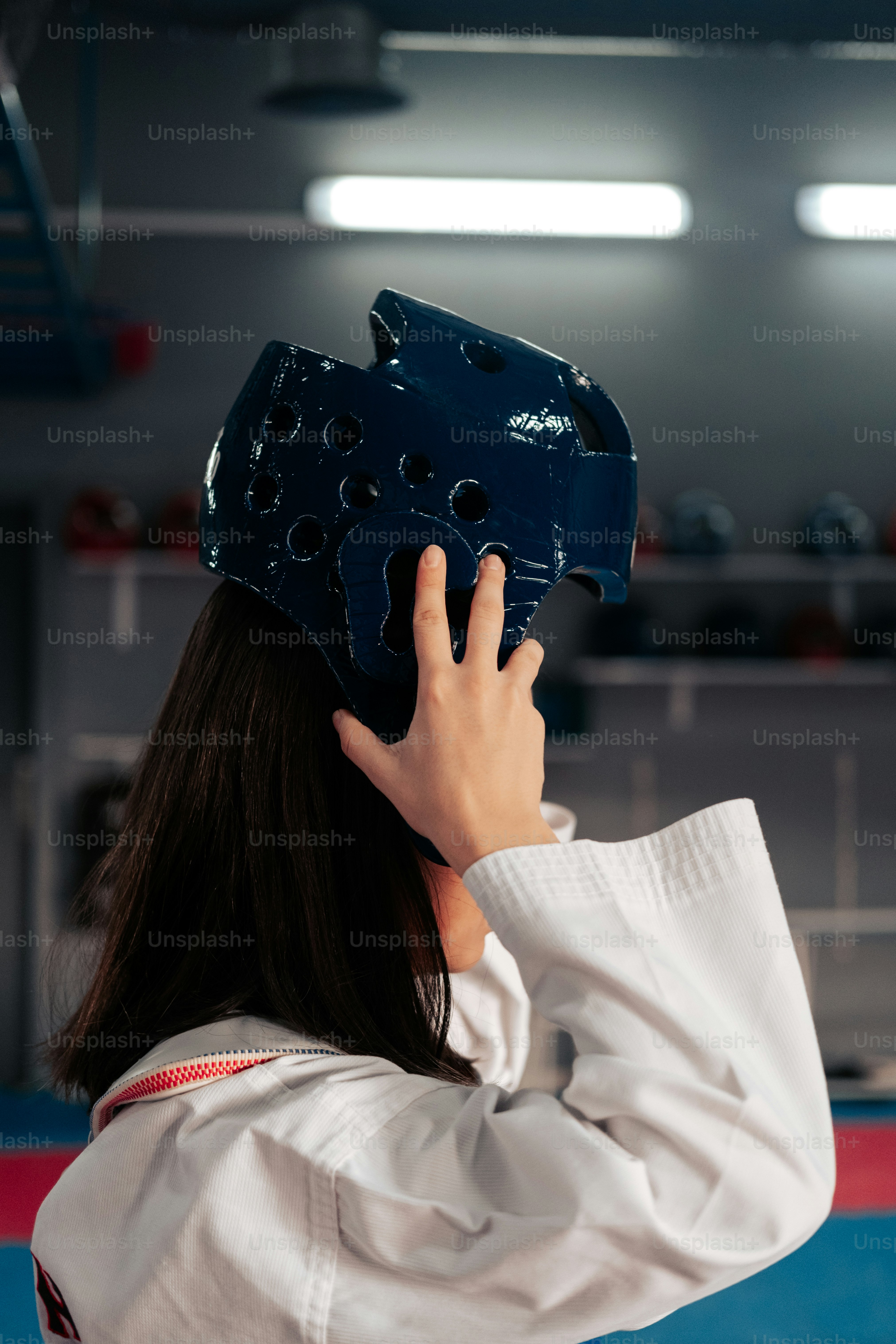 uma mulher usando um capacete azul enquanto está em pé em uma academia