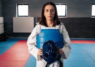 a woman holding a blue object in a gym
