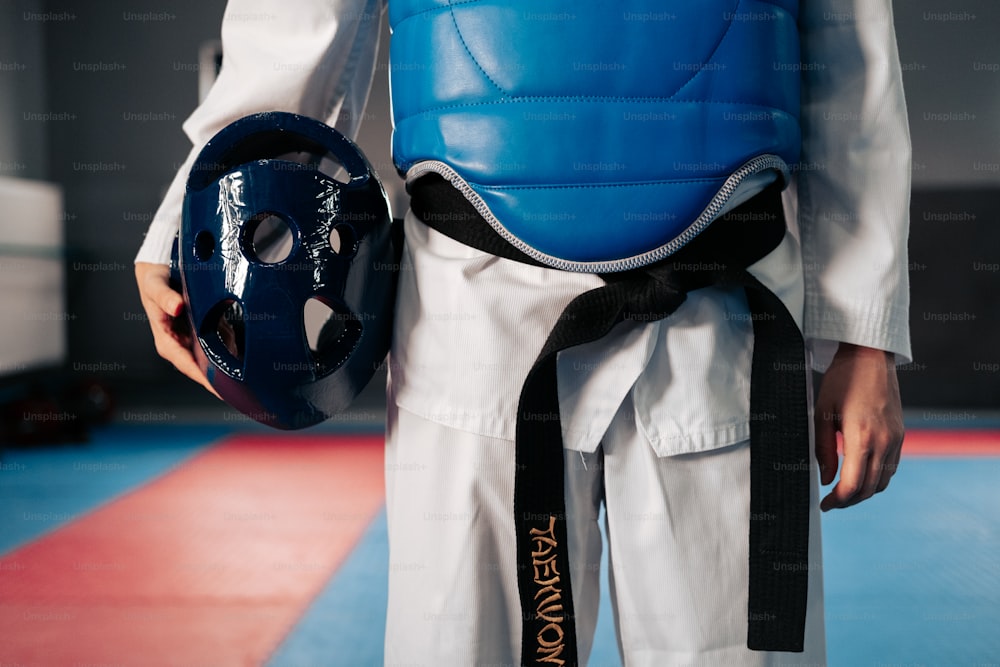 a person in a blue vest holding a blue helmet