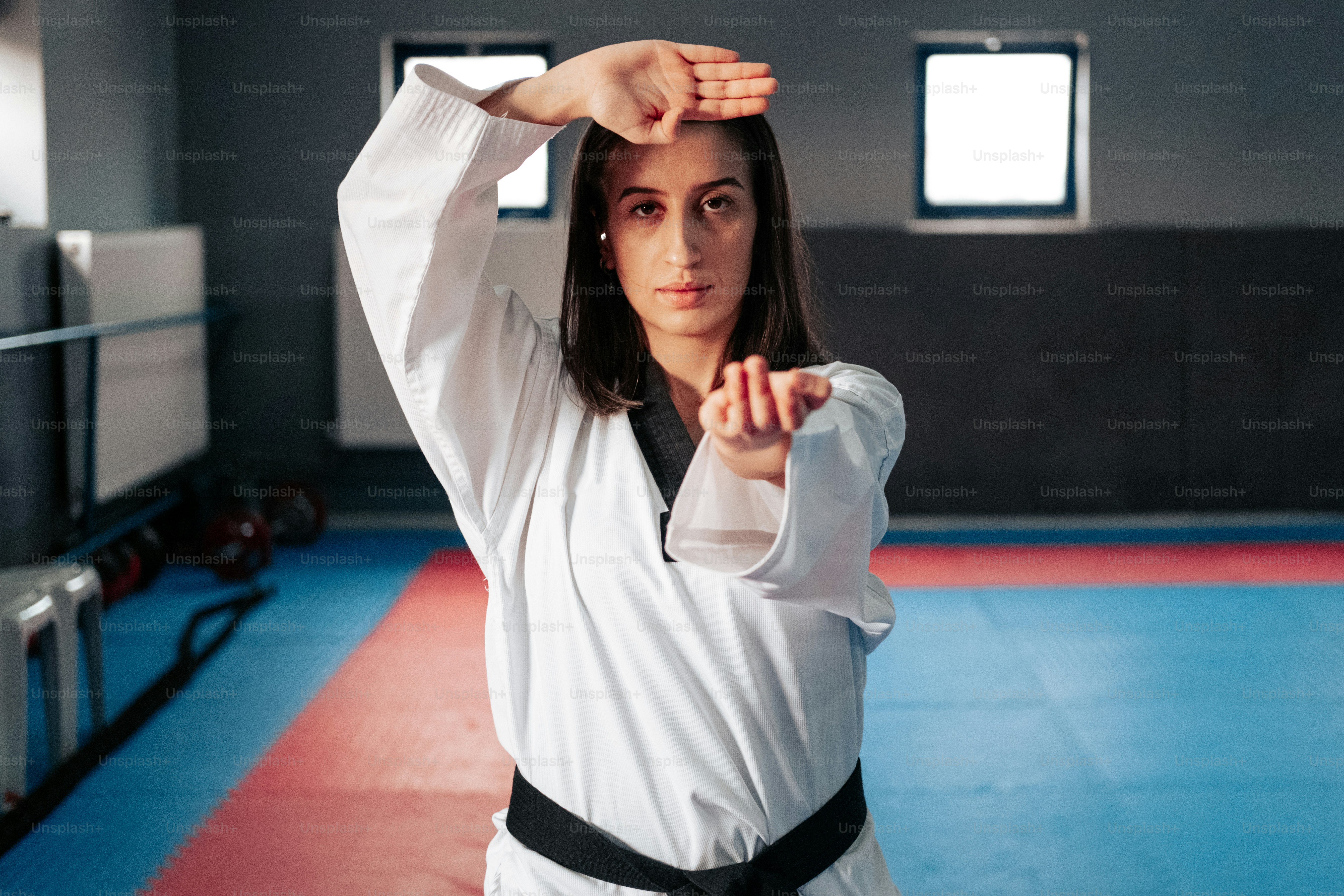 uma mulher em pé em uma academia segurando o braço para cima