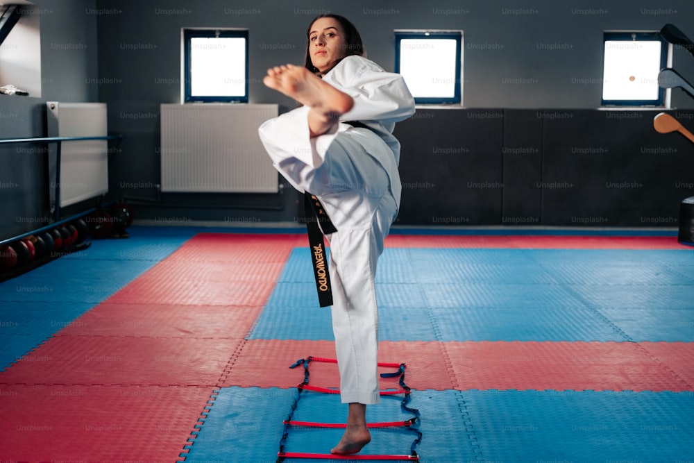 a woman in a karate stance on a mat