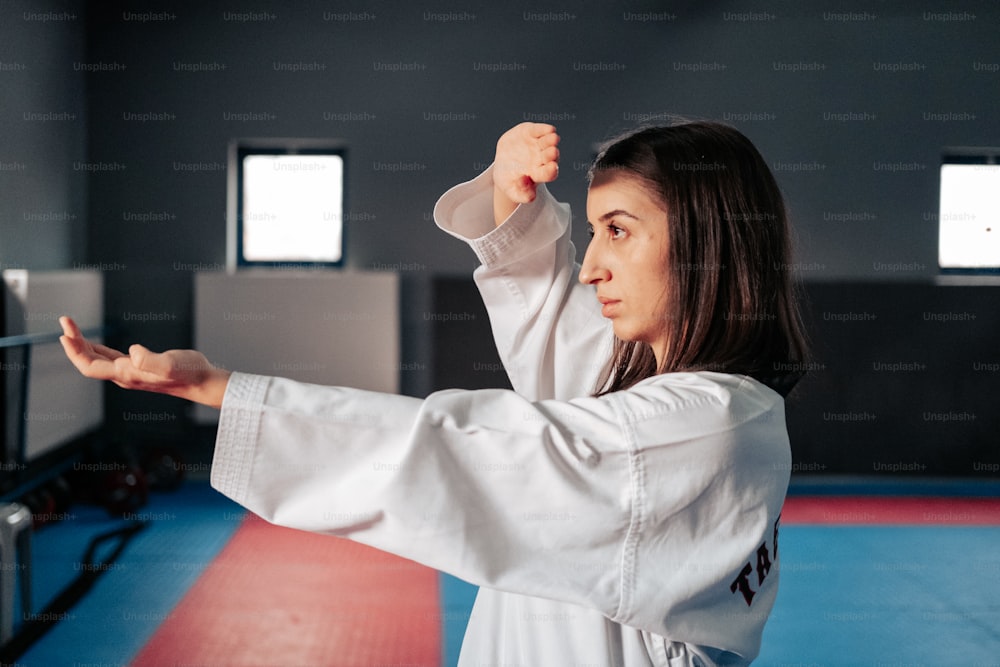 Una mujer está practicando karate en un gimnasio