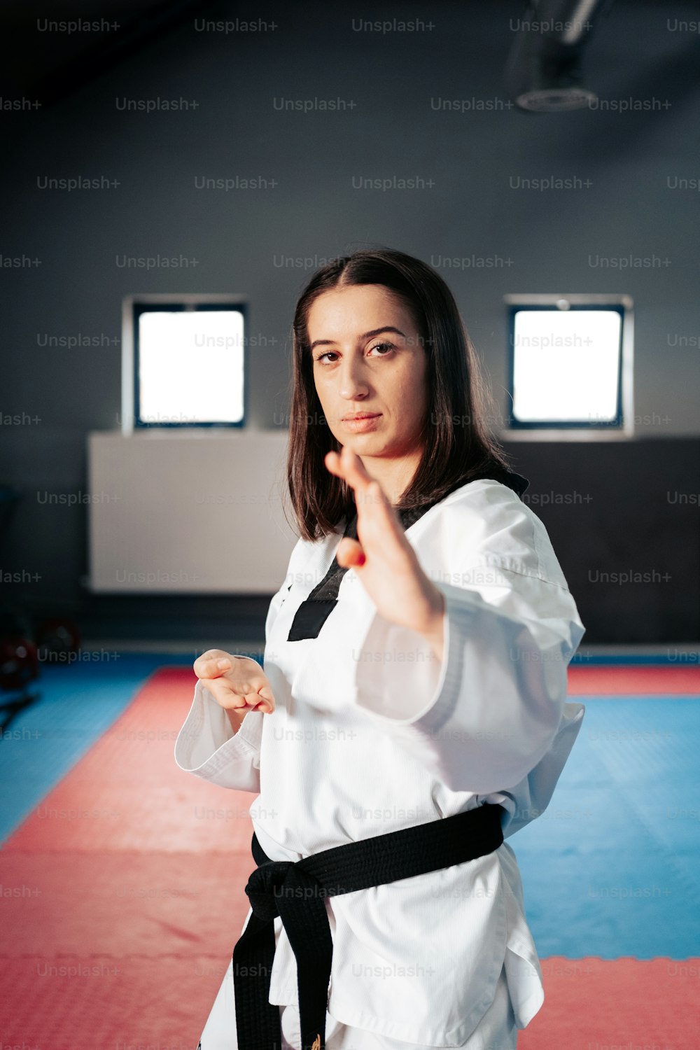 a woman standing in a room with a black belt
