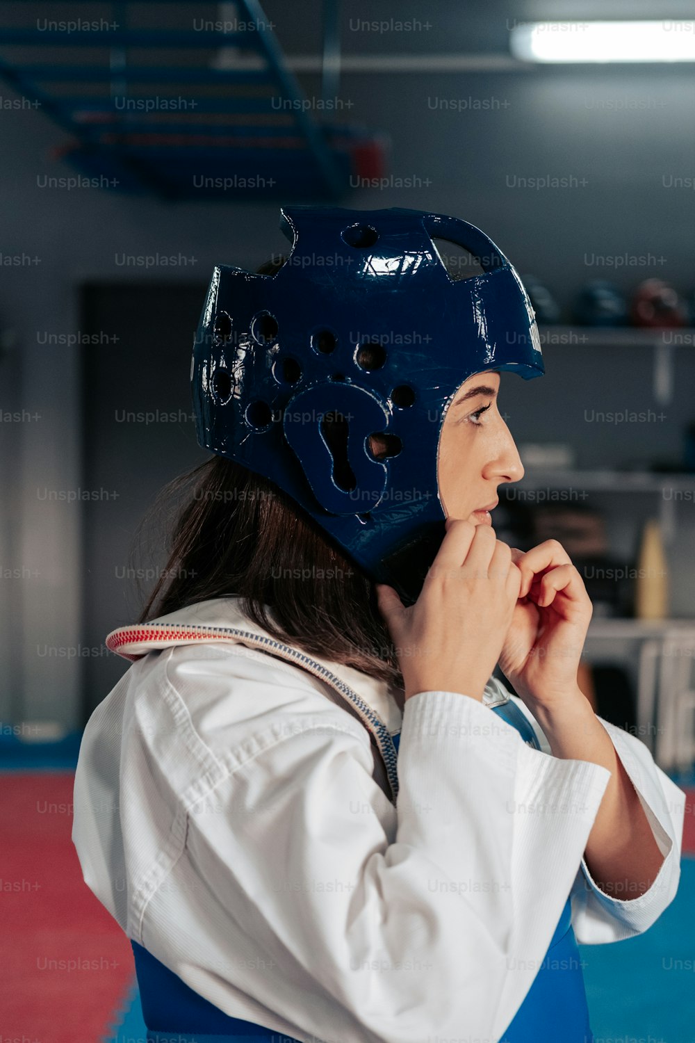 a woman wearing a blue helmet while standing in a gym