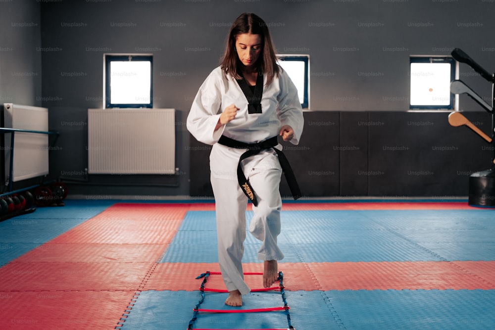 a woman standing on a mat in a gym
