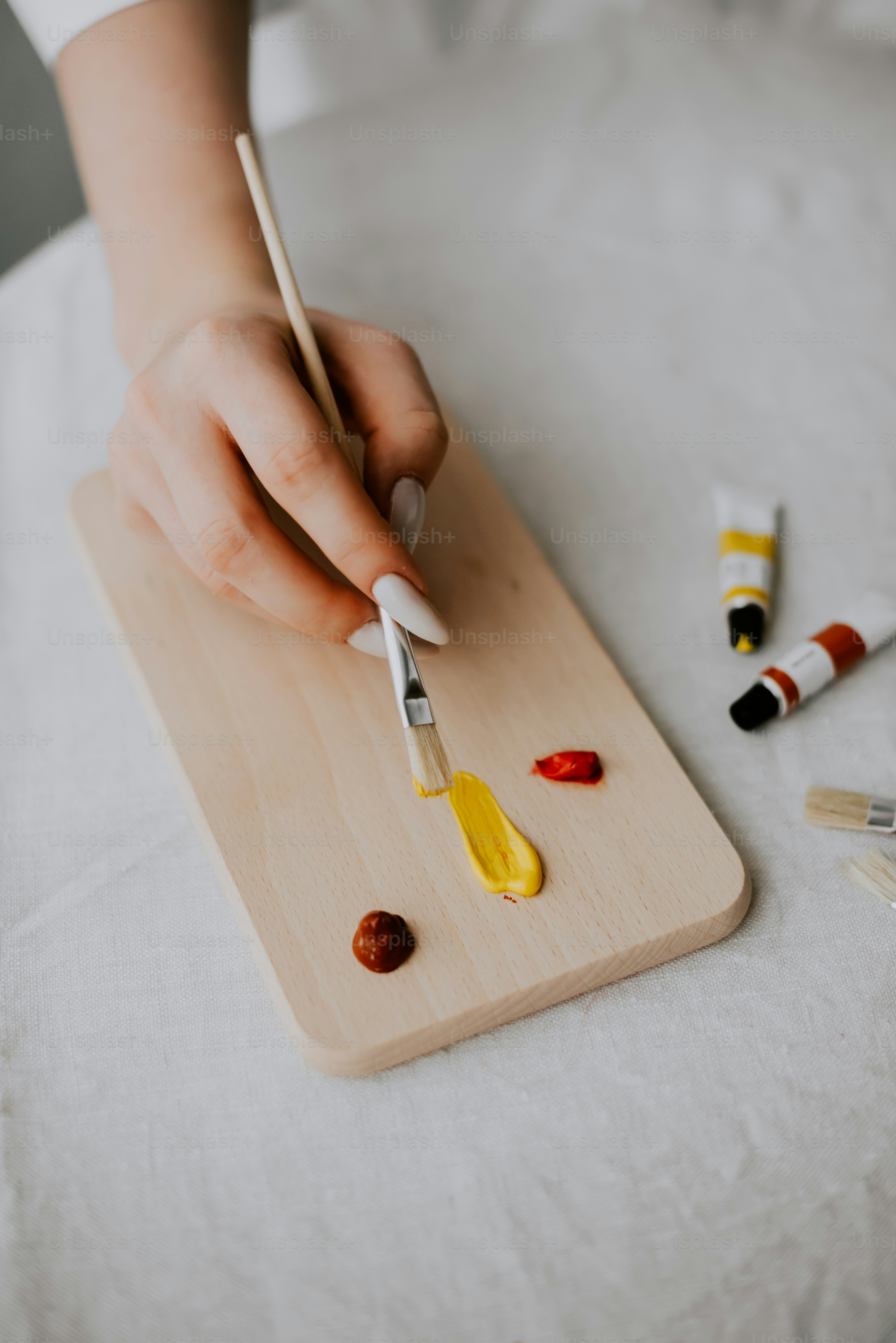 a person is painting on a wooden board