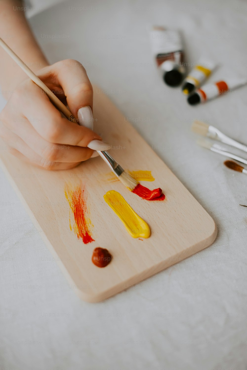 a person is painting on a wooden board