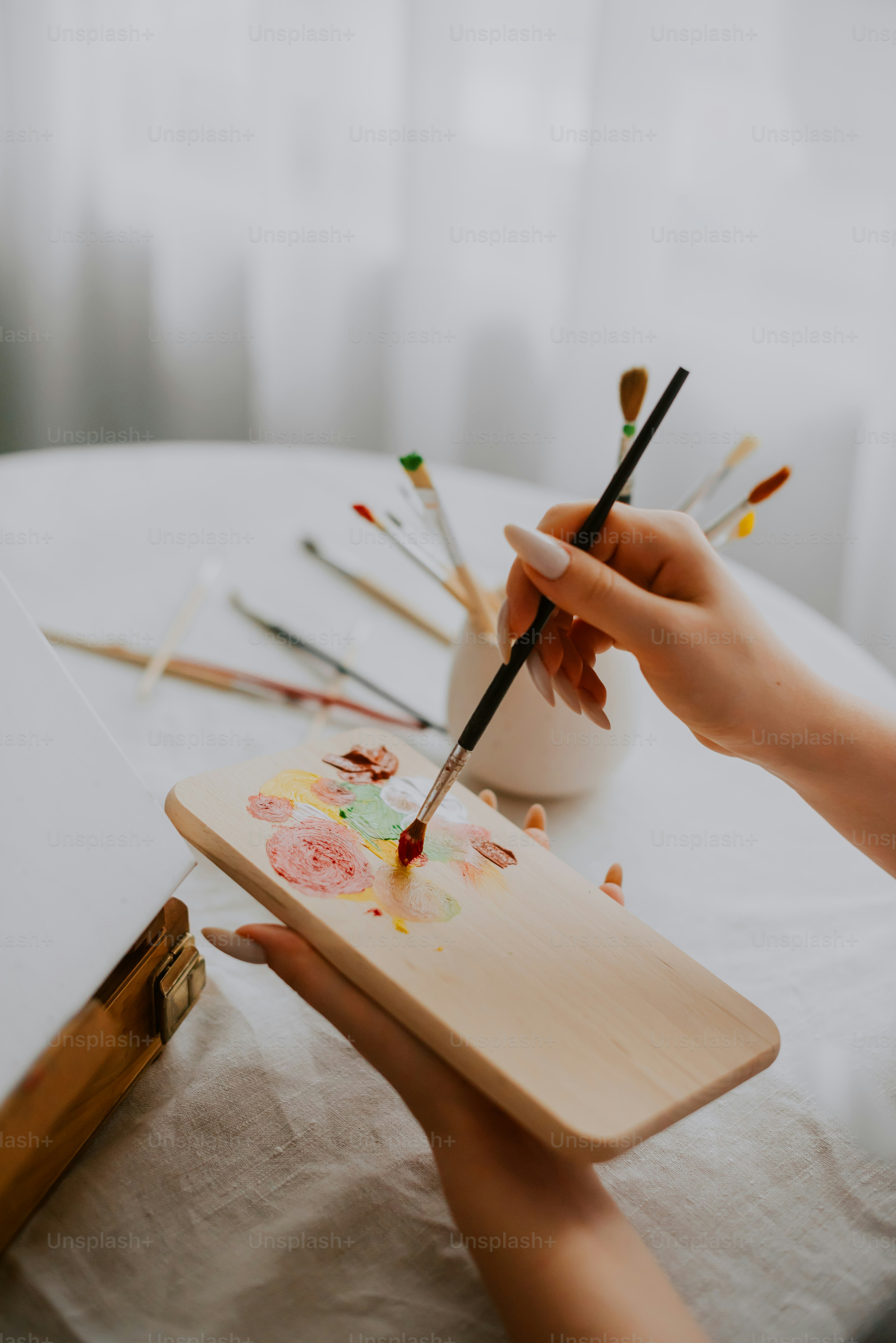 Una persona está pintando un cuadro en una tabla de madera
