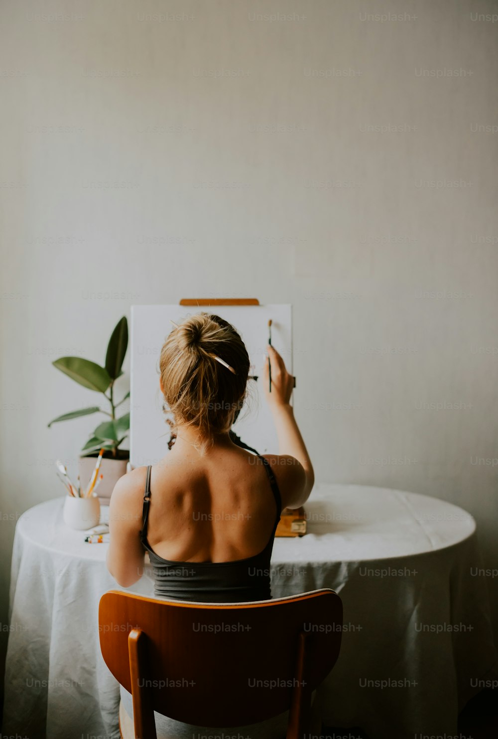 a woman sitting at a table taking a picture of herself