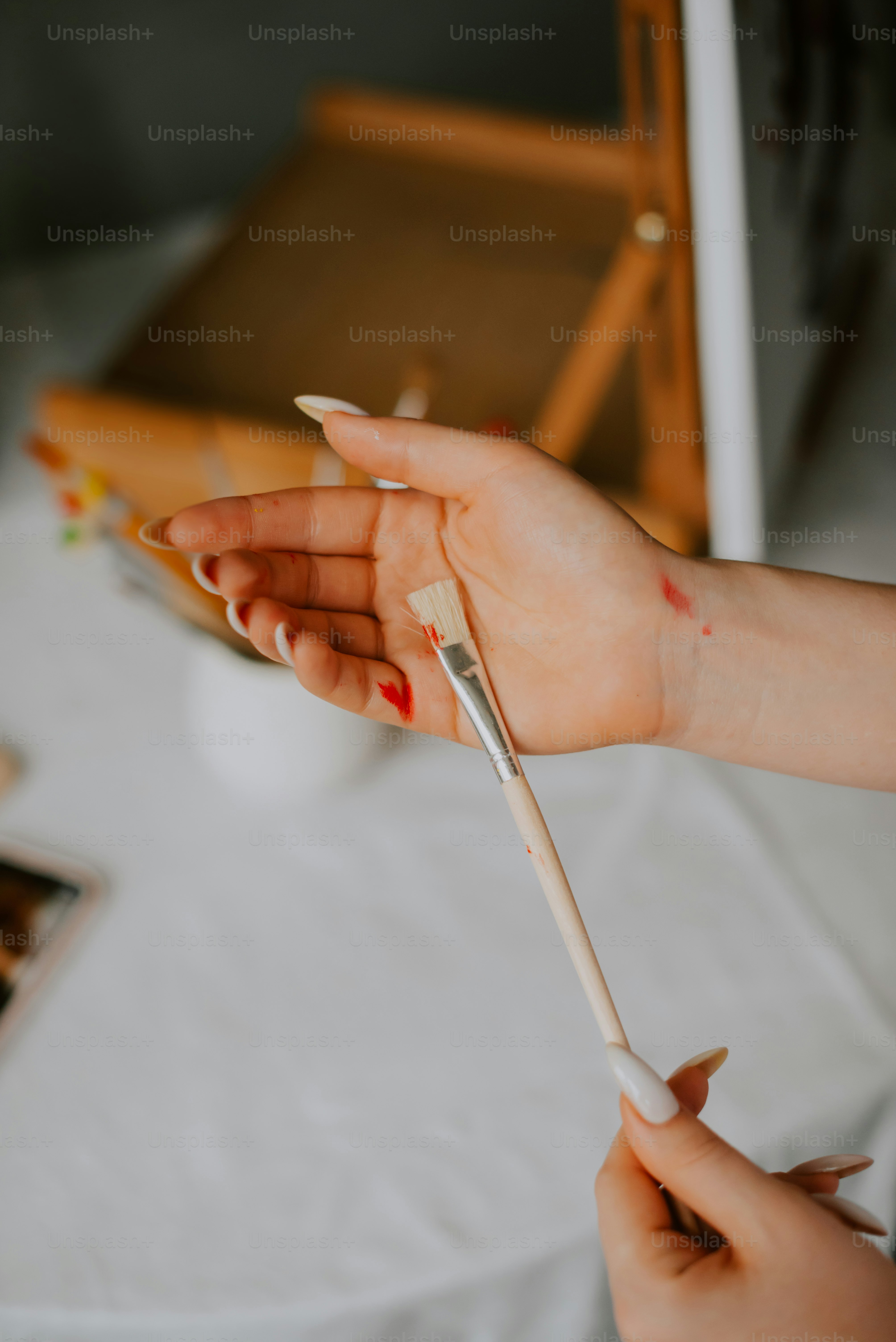 a woman holding a paintbrush and a paintbrush in her hand