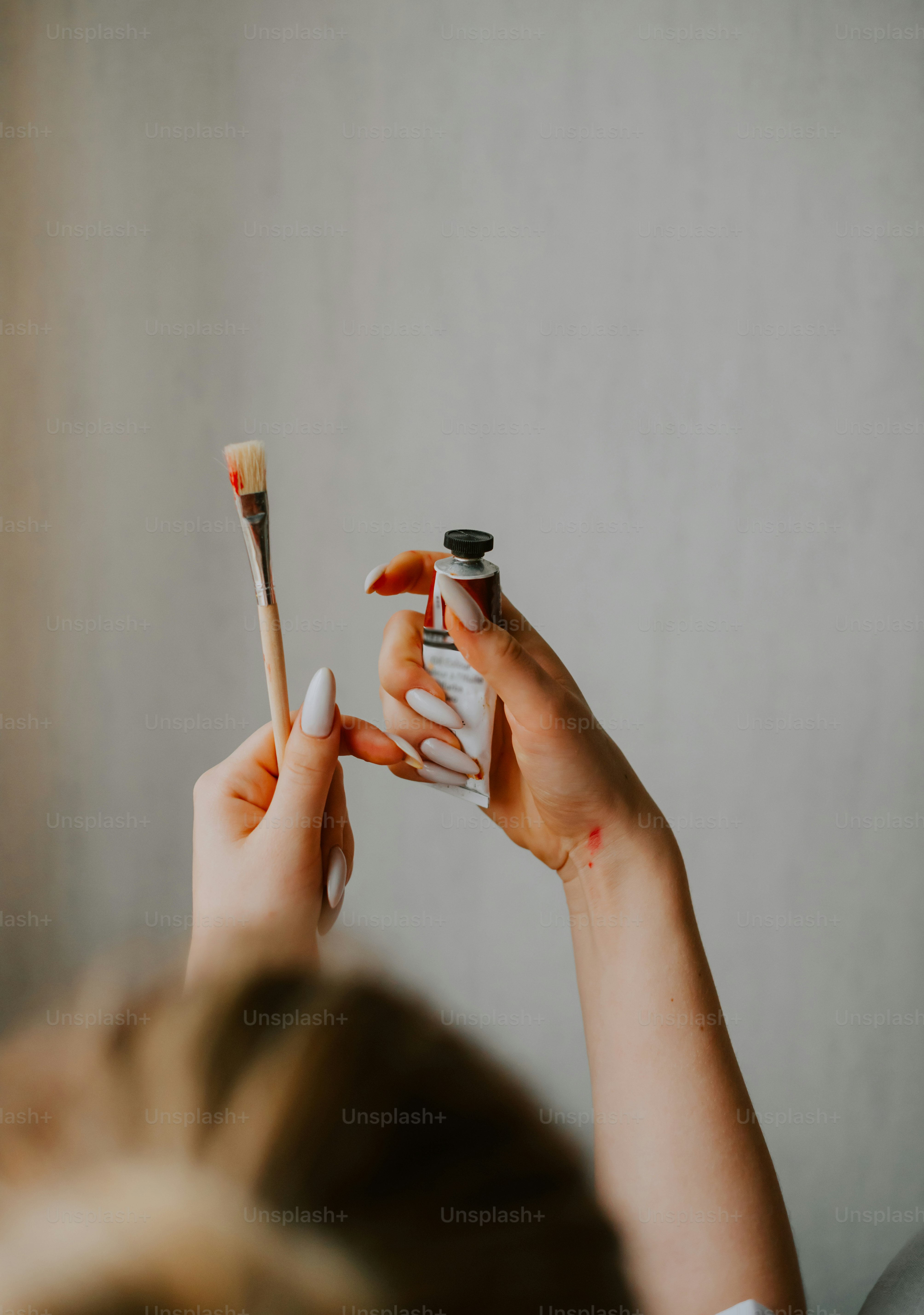 a woman holding a toothbrush and a tube of toothpaste