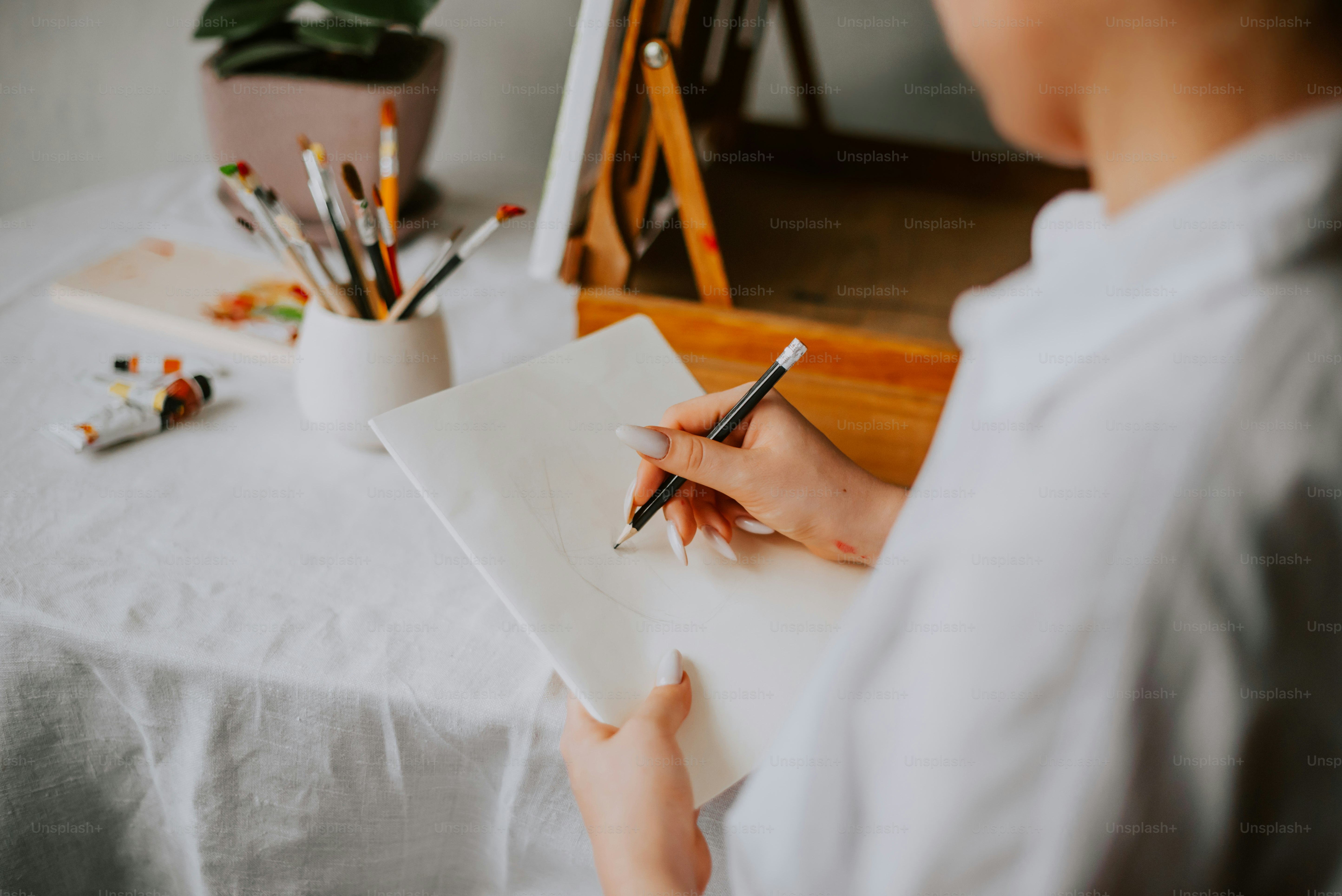 A woman is painting a picture on a easel photo – Painting Image on Unsplash